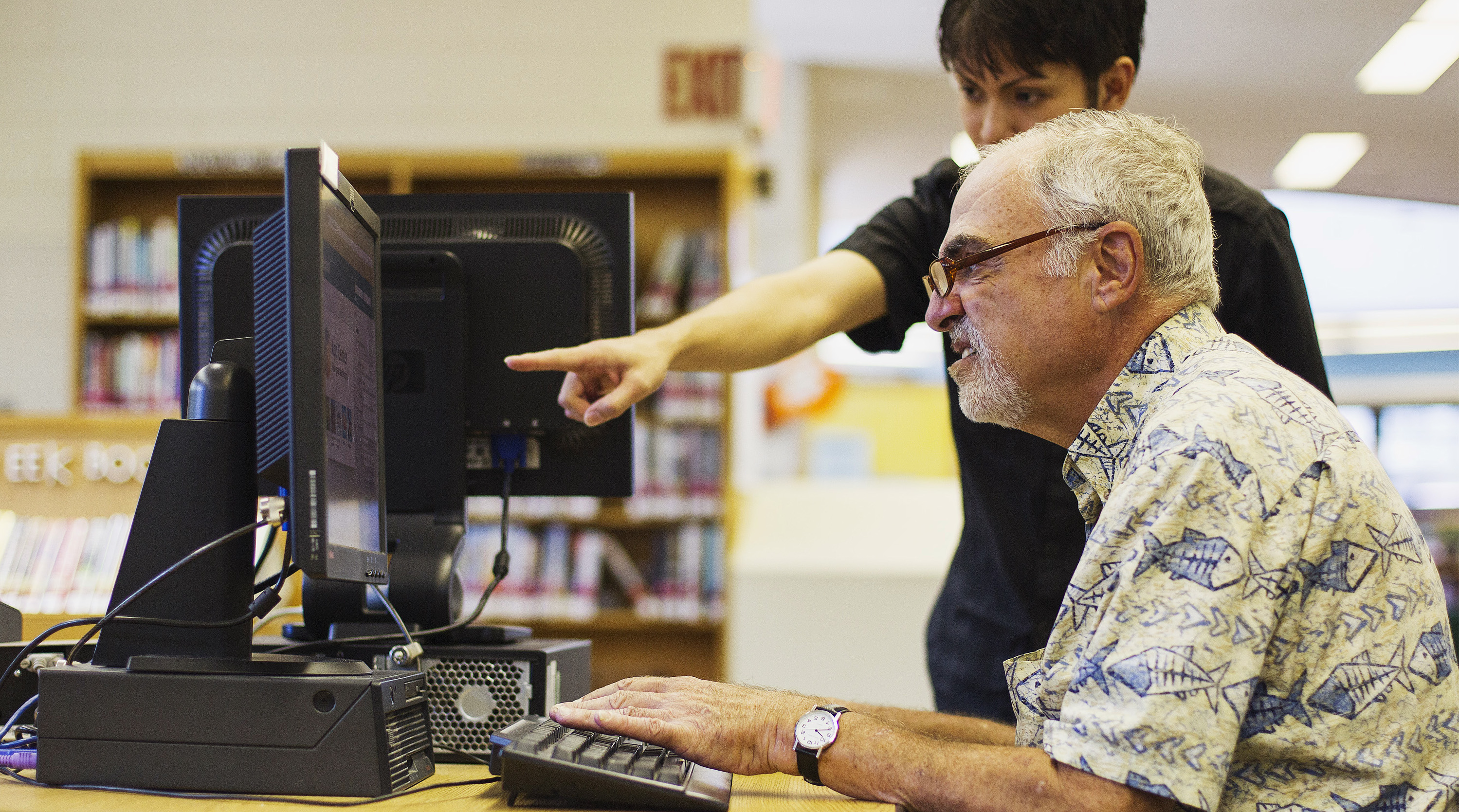 A librarian teaches a senior citizen how to use a Facebook account during a class at a branch of the New York Public Library in New York