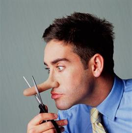 Young man cutting nose with scissors, side view, close-up