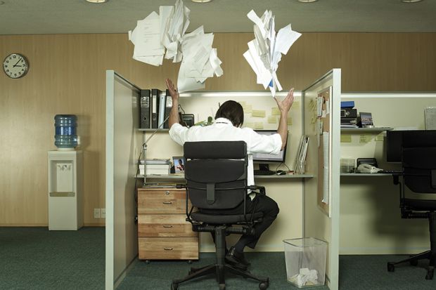 man-at-desk-throwing-papers-in-the-air
