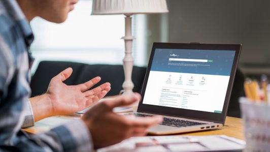 Page not found and error in laptop. Bad or slow internet connection. Frustrated man spreading hands in home office desk. Broken computer not working. Online information problem. Alert icon.
